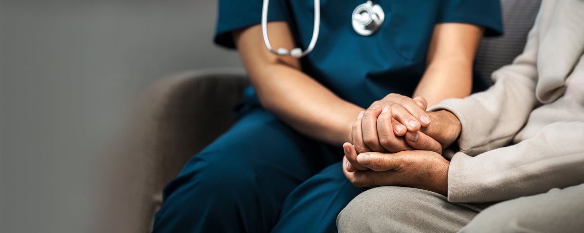 A Spring Meadows caregiver holding a resident's hand to offer comfort and reassurance