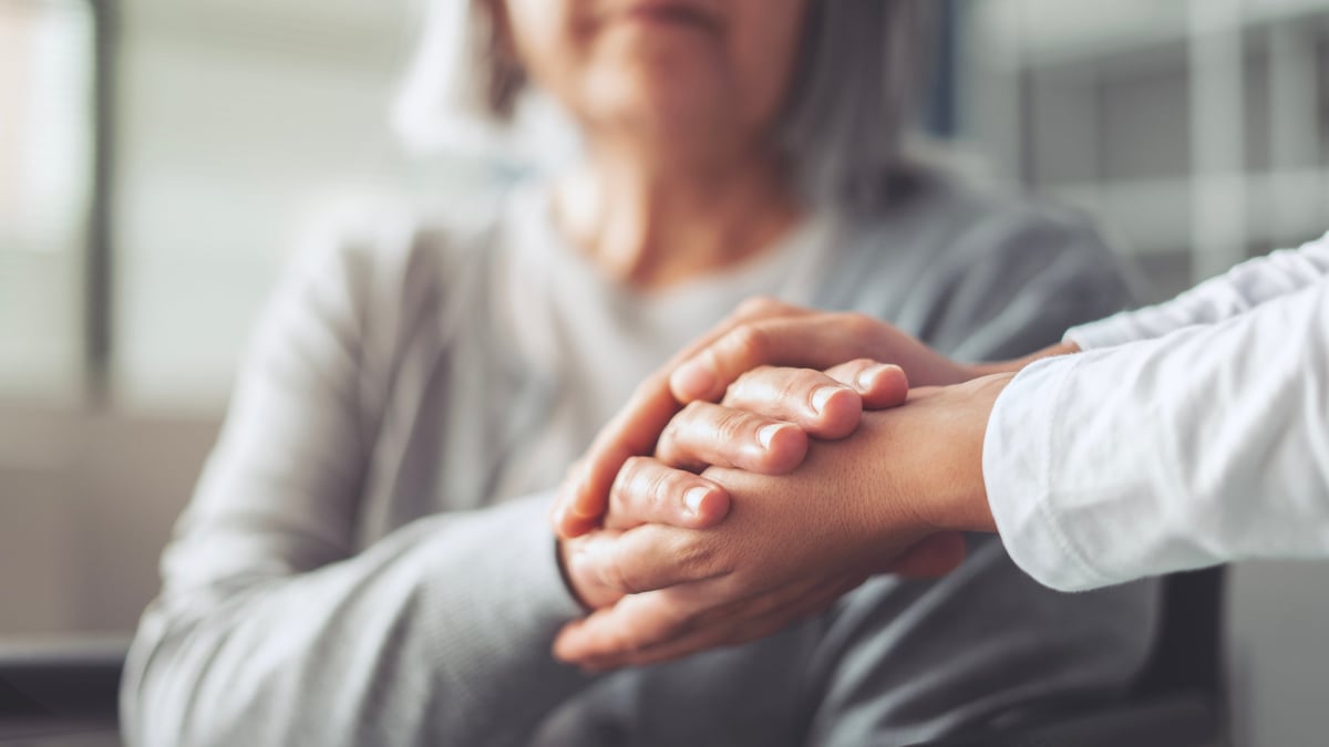 Two hands held gently together in comfort and trust